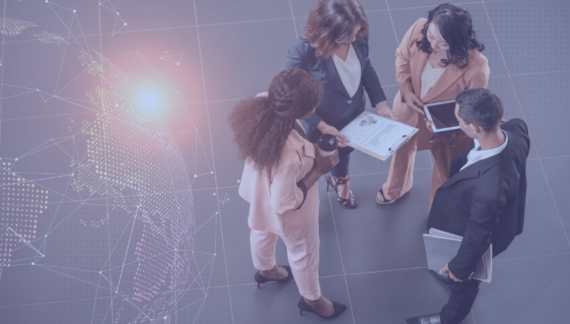 A diverse group of business people stands around a globe, representing global connections in IT outsourcing strategies to find solutions for question: How to Outsource Without Losing Expertise